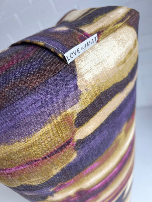 Colorful abstract print bolster with a visible brand label on a light background