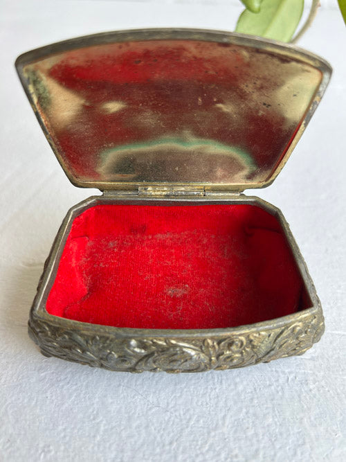 Vintage silver jewelry box with red interior on a white background