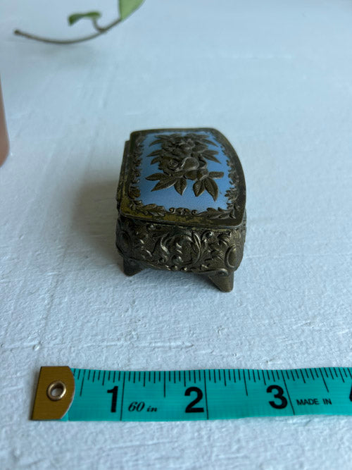 Decorative jewelry box with floral design on a white surface, measured by a ruler.