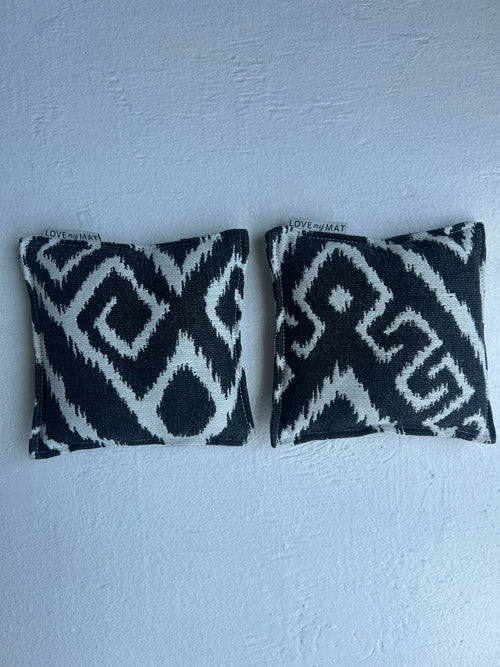 Two black and white patterned pillows on a light blue background