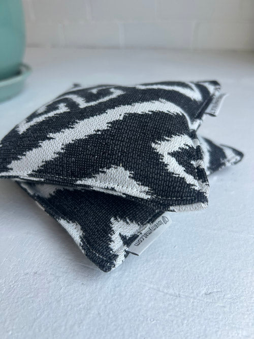 Black and white patterned pouches on a light surface