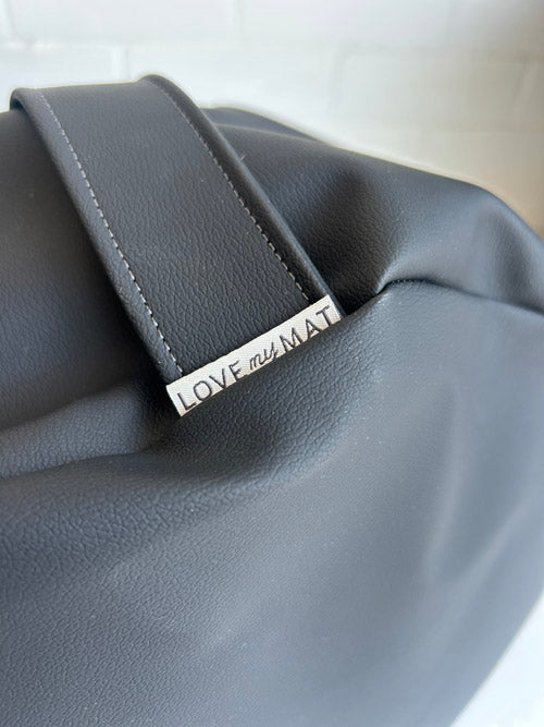 Gray leather bag with a visible brand name on a light background
