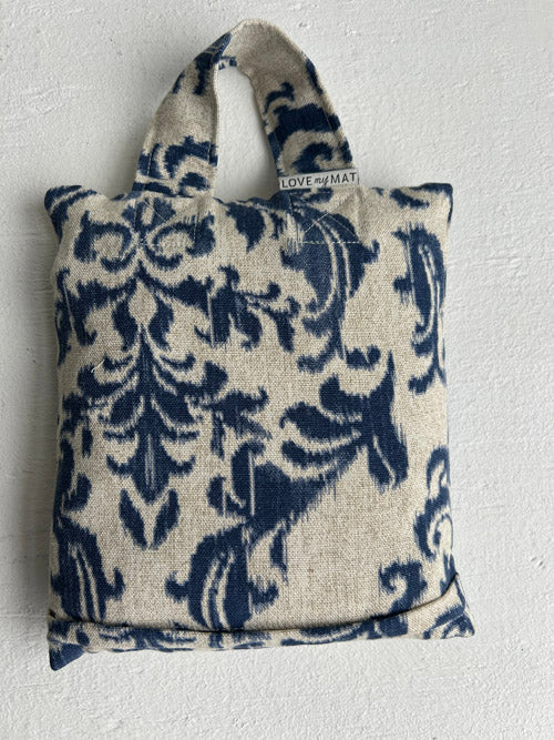 Decorative sandbag with blue floral pattern on a plain background
