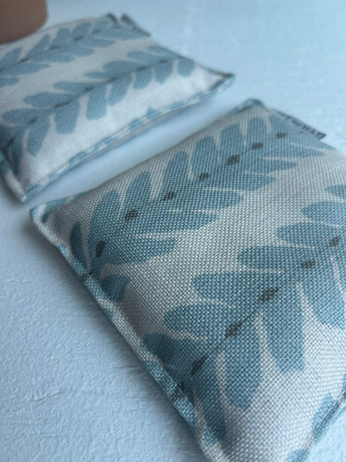 Two fabric yoga knee cushions with leaf pattern on a light background
