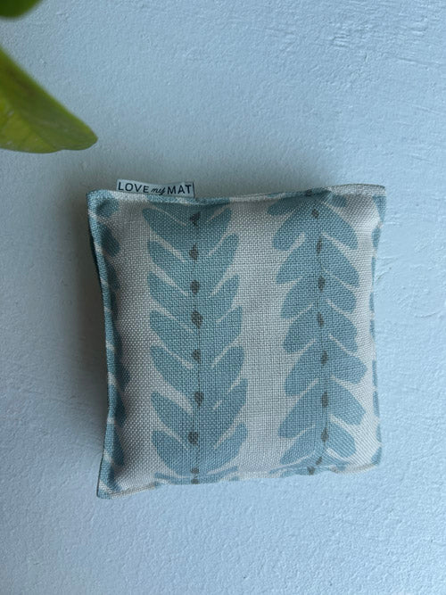 Fabric yoga knee cushions with leaf pattern on a light blue background