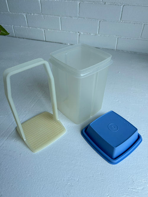 Three piece Tupperware, blue top clear base and clear elevator all on white background