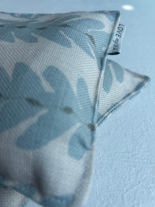Fabric knee pillows with vine pattern and 'LOVE' label on a light blue background