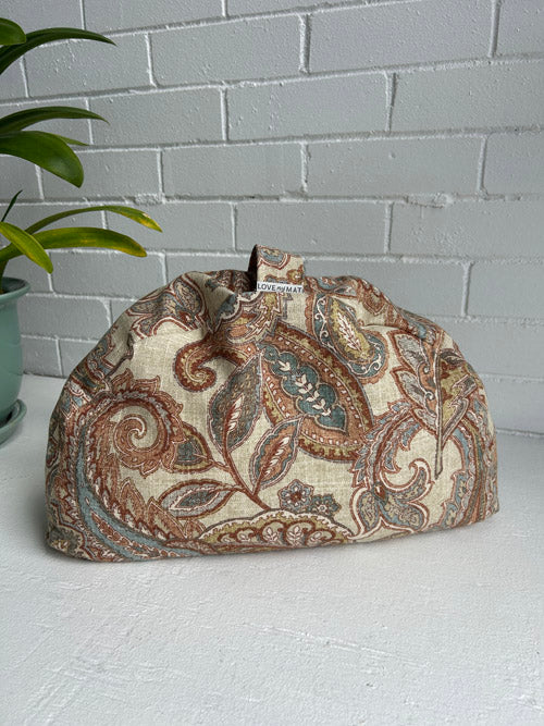 Fabric Meditation cushion with paisley pattern on a white surface and white brick wall background