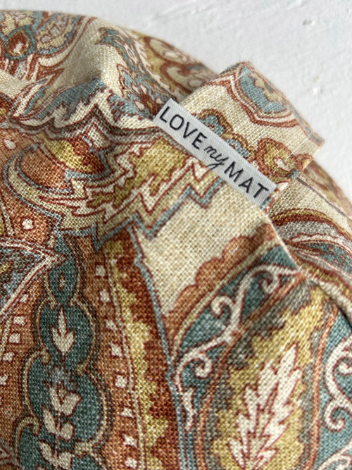 Close up of patterned fabric with a 'LOVE my MAT' label on a textured surface