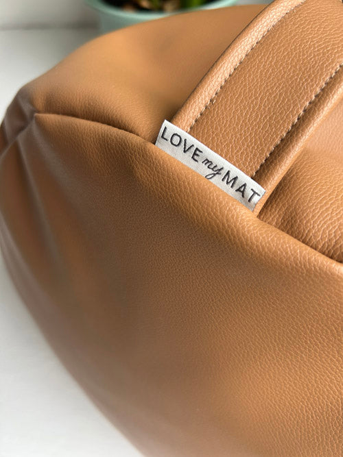Brown vinyl cushion with 'LOVE my MAT' label on a white surface