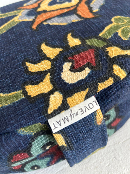 Close up of a fabric meditation cushion with a label that reads 'LOVE my MAT'