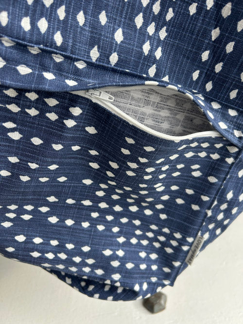 Close-up of a blue fabric with white patterns and a visible label.