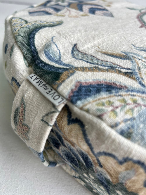 Close-up of a patterned fabric with a visible brand label on a white background