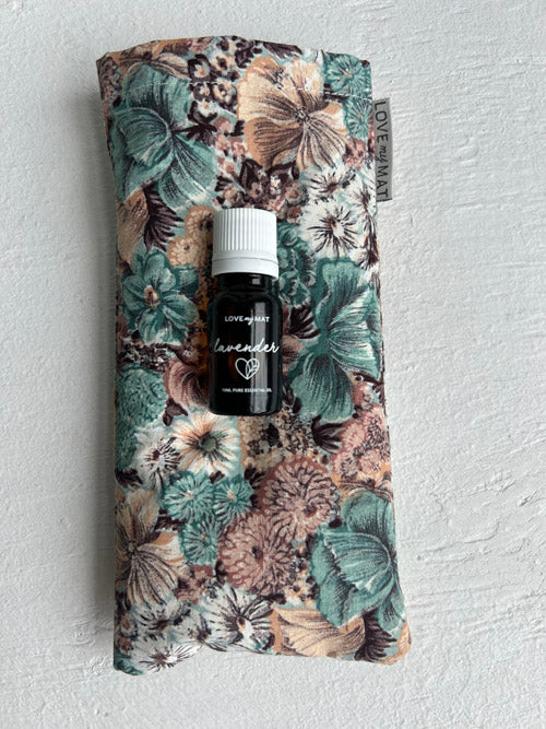 Lavender essential oil bottle on a floral fabric eye pillow