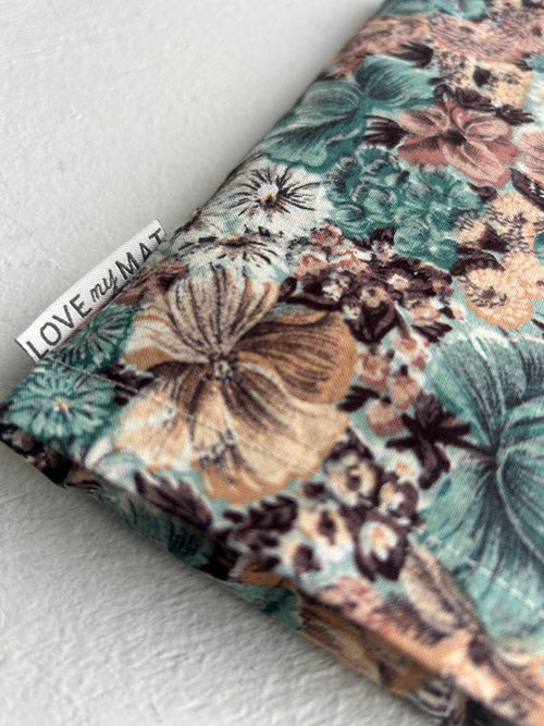 Floral-patterned eye pillow with 'LOVE my MAT' branding on a light background
