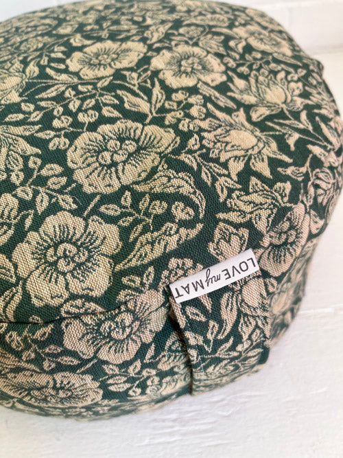 Floral-patterned green meditation floor cushion with a visible brand label 'LOVEmyMAT" on a white background