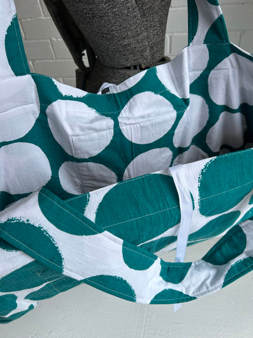 Green and white patterned bag on a gray surface