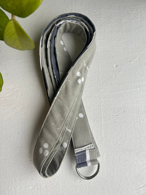 Greige Strap for yoga with white spots on a light gray background
