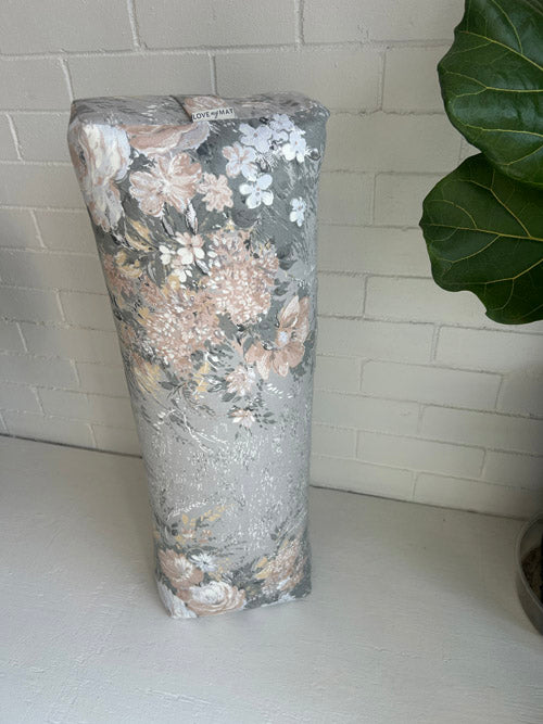 Decorative sustainable yoga bolster with floral pattern on a white surface