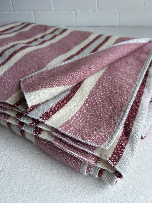 Folded fabric with red and cream stripes on a white surface