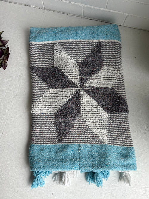 Textured blanket with leaf pattern on a white floor