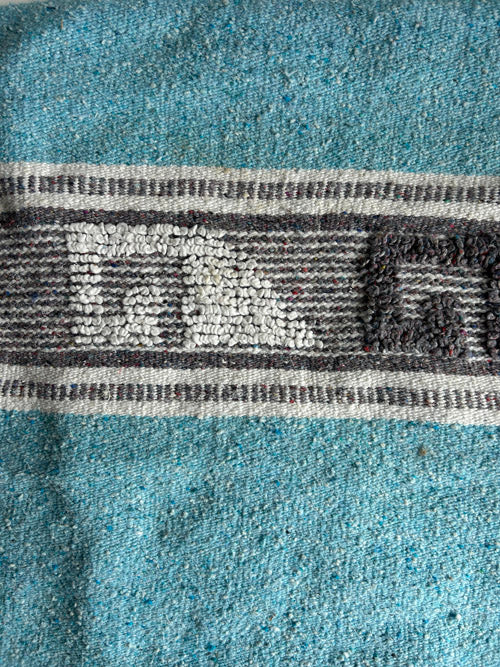 Close-up of a textured fabric with a patterned band in the center.