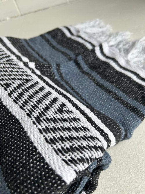 Blue, Black and white Mexican blanket on a light surface