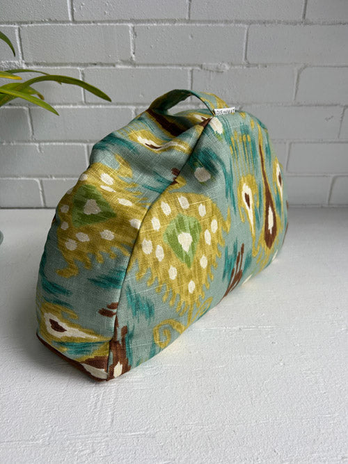 Fabric meditation cushion on a white surface with a white brick wall background