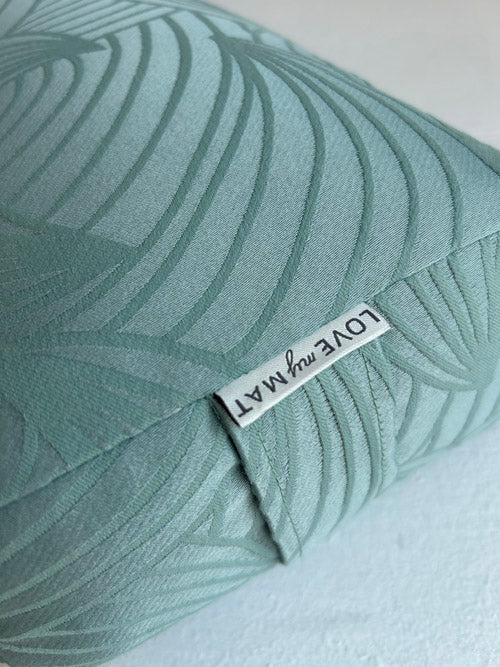 Teal yoga bolster with leaf pattern and 'LOVE my MAT' label on a white background