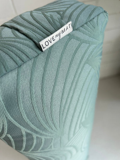 Green textured yoga bolster with 'LOVE MY MAT' label on a white background