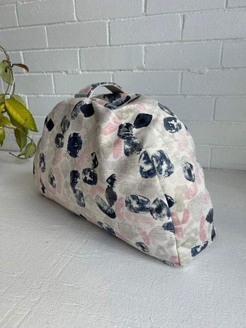 Meditation Cushion with navy and pink pattern on a white surface with a light gray tiled wall background