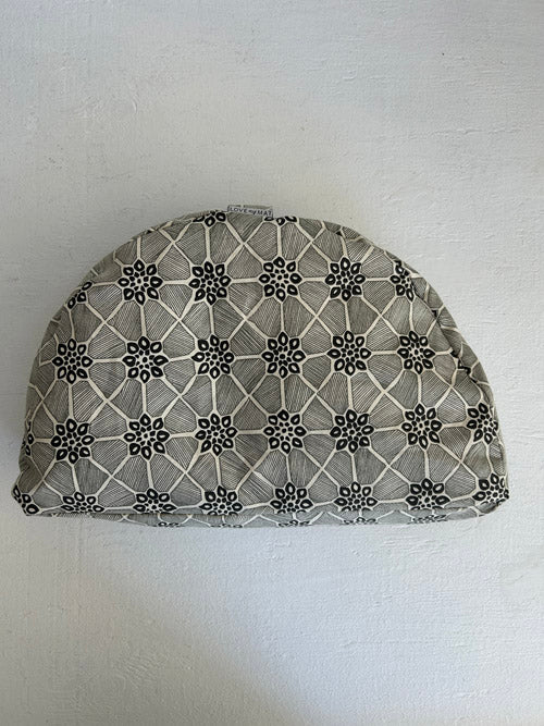 Fabric-covered meditation floor pillow with geometric pattern on a white background