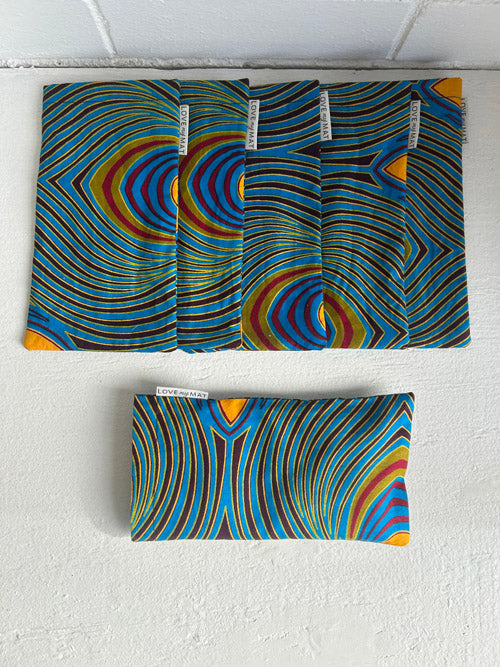 Six fabric eye pillows with a colorful abstract pattern on a white background.