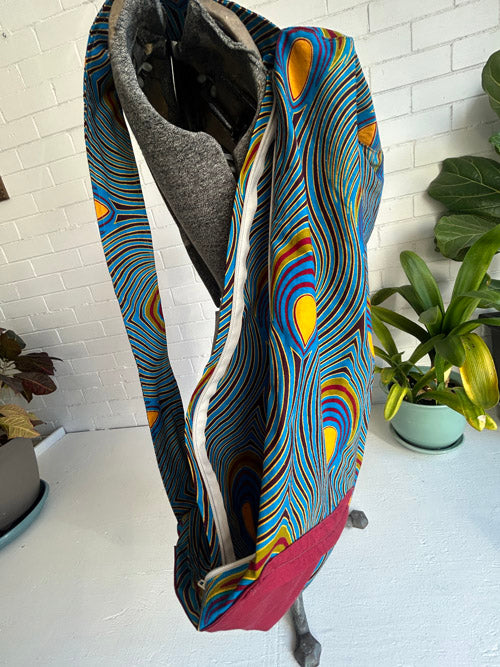 Colorful patterned yoga mat bag with a textured surface on a white surface.