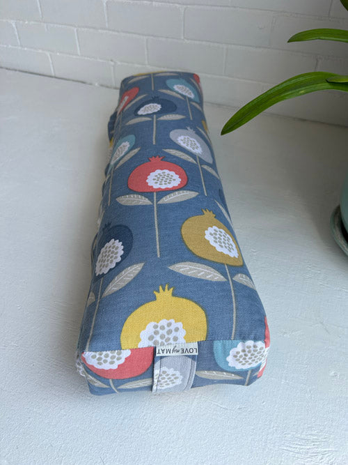 Rectangular fabric pillow with floral pattern on a white surface