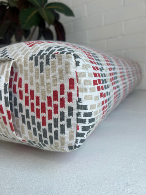 Fabric yoga bolster with geometric pattern on a white surface