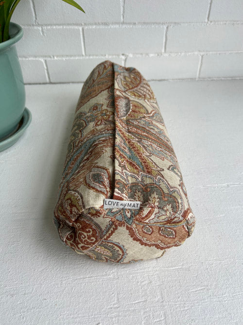 Fabric-wrapped round small bolster with 'LOVE my MAT' tag on a white surface.