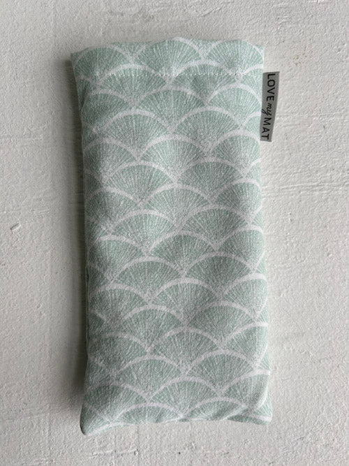 Green patterned eye pillow with 'LOVE' label on a white background