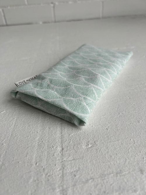 Ffabric eye pillow with leaf pattern on a white surface