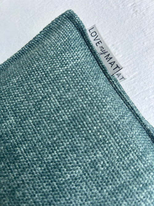 Textured green mat with a visible brand label on a light gray background
