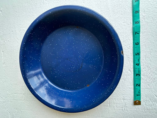 Blue enamel deep plate with white speckled pattern on a blue surface, accompanied by a measuring tape.