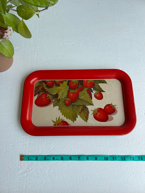 Rectangular tray with strawberry design on a white surface, accompanied by a measuring tape for scale.