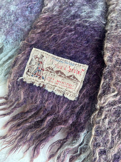 Close-up of a textured fabric with a label featuring a person and mountain design.
