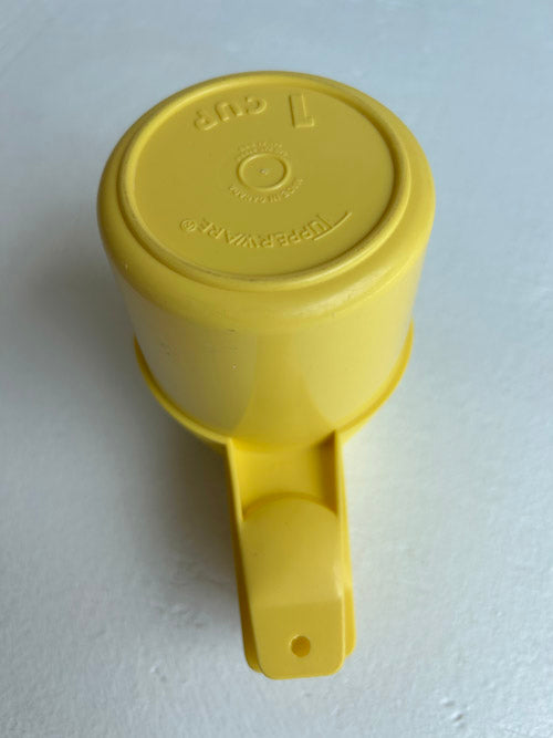 Yellow measuring cup with handle on a white background