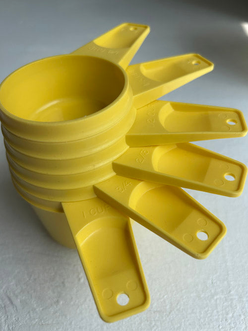 Yellow plastic funnel-like device on a white background